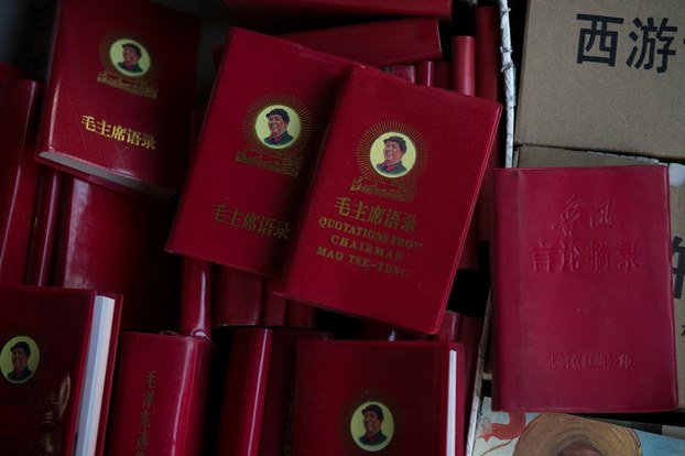 Red booklets, each containing a small picture of Mao Zedong.