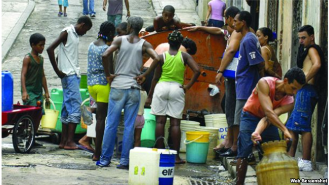 A group of people gather by the foundation with their buckets to retrieve water
